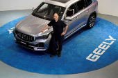 FILE PHOTO: Zhejiang Geely Holding Group's Chairman Li Shufu poses for pictures next to a Xingyue L SUV at Geely headquarters in Hangzhou