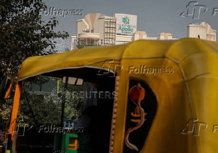 FILE PHOTO: A driver parks an auto-rickshaw in front of an Apollo Hospital building in New Delhi