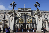 Tourists take pictures of Buckingham palace in London