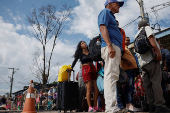 Venezuelans queue to enter a shelter after leaving Venezuela, in Pacaraima