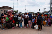 Venezuelans queue to enter a shelter after leaving Venezuela, in Pacaraima