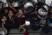 Displaced Palestinians collect donated food in Khan Yunis, southern Gaza