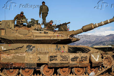 Israeli soldiers work on a tank, amid cross-border hostilities between Hezbollah and Israel, by Israel's border with Lebanon