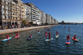 Members of the ThesSUP team wearing Santa Claus costumes paddle off the seafront of Thessaloniki