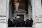 Officers from the New York City Police Department (NYPD) stand guard on the steps of the New York Public Library