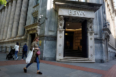 FILE PHOTO: A woman walks past a branch of Spain's BBVA bank in the Gran Via of Bilbao