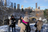 People take photographs in Central Park, in New York