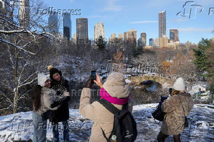 People take photographs in Central Park, in New York