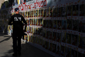 People walk past posters of hostages kidnapped in the October 7 attack by Hamas, in Tel Aviv