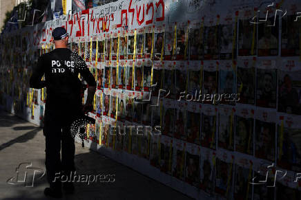 People walk past posters of hostages kidnapped in the October 7 attack by Hamas, in Tel Aviv
