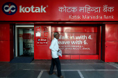 FILE PHOTO: A man walks past the Kotak Mahindra Bank branch in New Delhi
