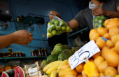 A person buys lemons at a stall in a market in Monterrey