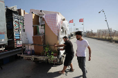 Syrian returnee Ahmed Al-hadid, loads his belongings onto a truck, in Aleppo's countryside