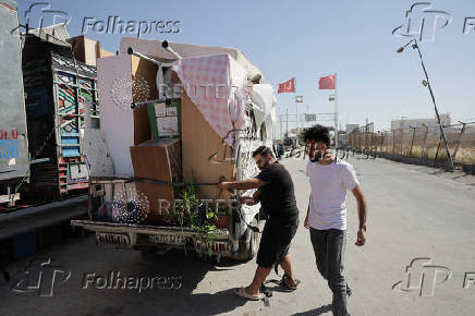 Syrian returnee Ahmed Al-hadid, loads his belongings onto a truck, in Aleppo's countryside