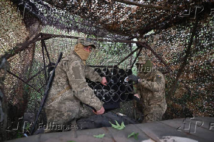 Ukrainian servicemen prepare a multiple rocket launcher before firing towards Russian troops on a front line in Zaporizhzhia region