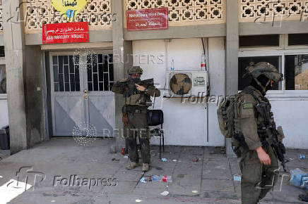 Israeli soldiers stand at the entrance to the European Hospital in Khan Younis at the Gaza Strip, where they found a tunnel underneath it