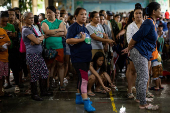 Residents affected by monsoon rains queue for relief following monsoon rains in Quezon City