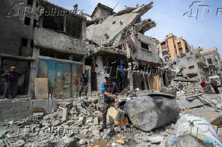 Palestinians inspect the site of an Israeli strike on a house, in Gaza City