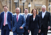 Britain?s Reform Party leader Farage walks with fellow Reform MPs, including newly elected MP Pochin into Houses of Parliament in London