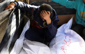 A mourner reacts besides the bodies of members of the Al-Arabeed family killed in Israeli strikes, at Al Shifa hospital, in Gaza City