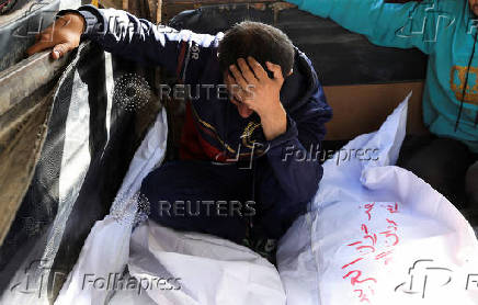 A mourner reacts besides the bodies of members of the Al-Arabeed family killed in Israeli strikes, at Al Shifa hospital, in Gaza City