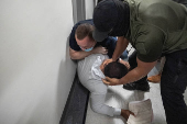 A migrant is detained by federal immigration officers at U.S. immigration court