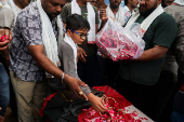 Son of Chetnaba Chavda and Ranvirsinh Chavda who died in the Air India Boeing 787-8 Dreamliner plane crash, offers flower petals to his parents coffin, in Ahmedabad