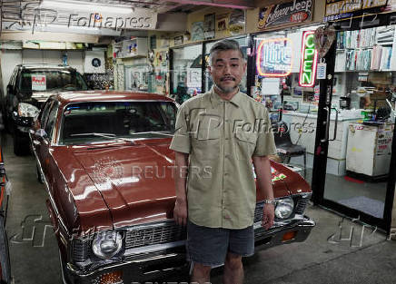 Importer of vintage American cars, Yumihito Yasue, poses at his office during an interview with Reuters in Tokyo