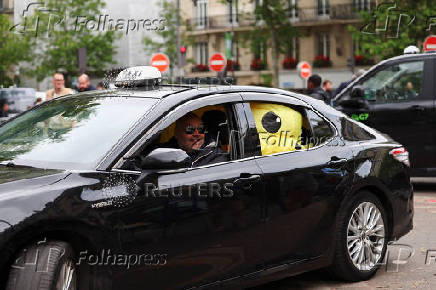 French taxi drivers gather for a strike protesting over proposed government cuts to cash for ferrying patients to and from medical appointments, in Paris