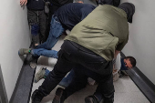 A migrant is detained by federal immigration officers at U.S. immigration court