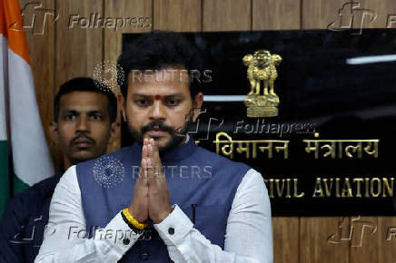 India's Civil Aviation Minister Ram Mohan Naidu gestures as he observes a minute's silence upon his arrival to attend a press conference in New Delhi