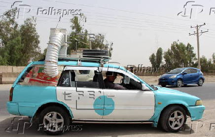 Taxi drivers install locally made air coolers to beat the heat in Kandahar