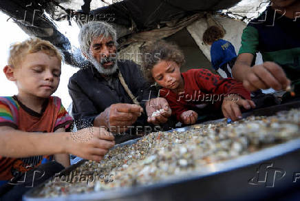 Displaced Palestinians who have not received humanitarian aid survive on leftover food, in Gaza