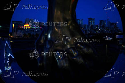 The MI6 building is see through a sculpture as it is illuminated to mark the  Pride in London Parade in London