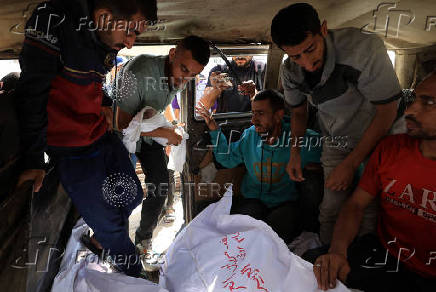 A Palestinian mourner carries the body of the stillborn baby of Palestinian woman Seham Al-Arabeed, who was killed in an a Israeli strike, according to medics, in Gaza City