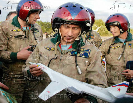 FILE PHOTO: Russian President Vladimir Putin looks at a model of the Tupolev TU-160 bomber..
