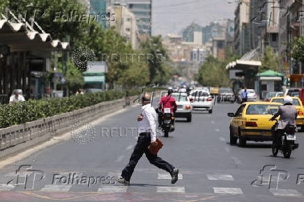 A man crosses street in Tehran