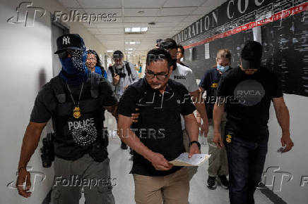 A migrant is detained by federal immigration officers at U.S. immigration court