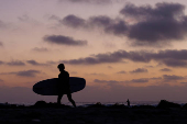 Surfer leaves the oceen after sunet in California