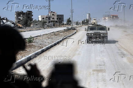 An Israeli military vehicle drives in a street in the Gaza Strip as it is seen from another Israeli military vehicle amid the ongoing ground operation of the Israeli army against Palestinian Islamist group Hamas