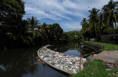 FILE PHOTO: A barrier in the water stops discarded plastics and other materials from flowing into the sea, in Colombo
