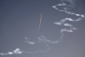 A military aircraft flies in the sky following a barrage of missiles launched from Iran, as seen over Tubas