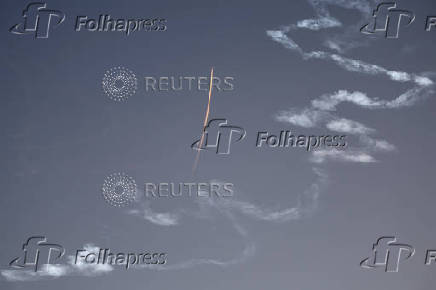 A military aircraft flies in the sky following a barrage of missiles launched from Iran, as seen over Tubas
