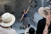 A woman poses for a photo outside the new Louis Vuitton store in Shanghai