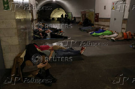 People take shelter inside a metro station during a Russian drone and missile strike in Kyiv
