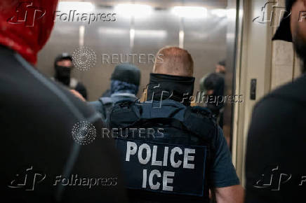 A migrant is detained by federal immigration officers at U.S. immigration court