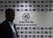 A man walks past the Reserve Bank of India (RBI) logo inside its headquarters in Mumbai