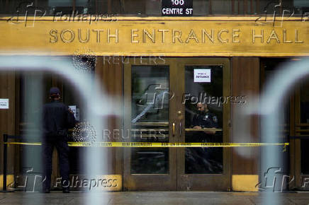 Police officers stand guard at the entrance of the Mahattan Criminal Court in New York