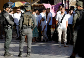 Israeli troops stand guard during a weekly settlers' tour in Hebron