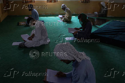 Students take a religious studies exam at a madrasa in Multan